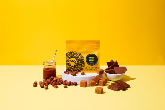 Lost Sheep Coffee's Fifty Fifty in yellow packaging surrounded by Chocolate, nuts and caramel tasting notes