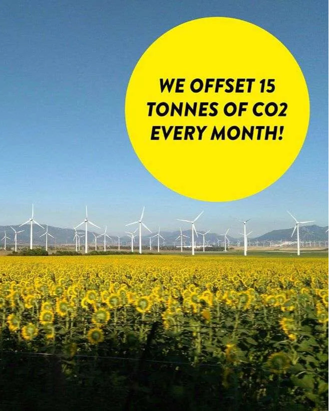 Sunflower field with wind turbines in the background and a yellow circle with text about CO2 offsetting.