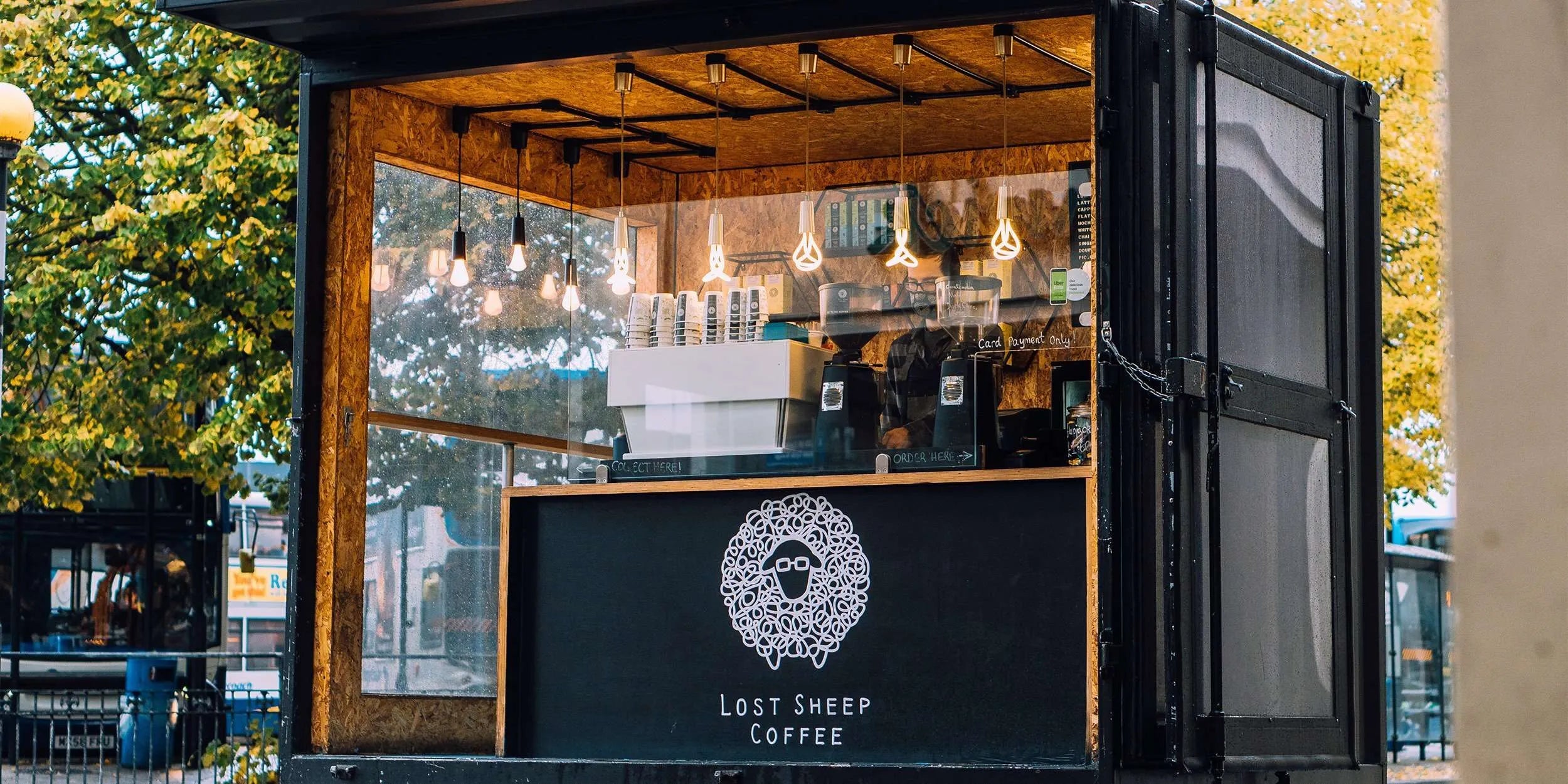 Container coffee shop with 'Lost Sheep Coffee' branding in an outdoor setting.