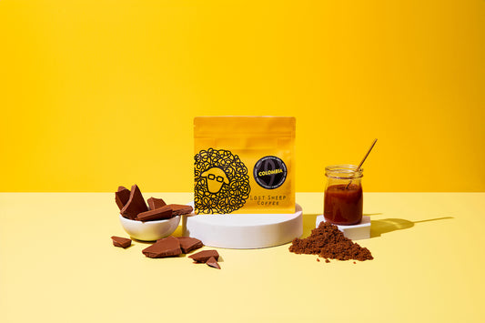 Lost Sheep Coffee's Colombia Single Origin in yellow packaging surrounded by Caramel, brown sugar and milk chocolate tasting notes 