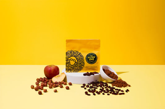 Lost Sheep Coffee's The Filter One in yellow packaging surrounded by Apple, brown sugar, hazelnuts and raisin tasting notes 