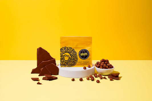 Lost Sheep Coffee's Brazil Single Origin in yellow packaging surrounded by Milk chocolate and hazelnut tasting notes 