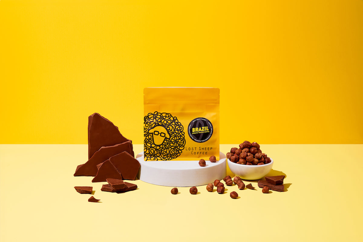 Lost Sheep Coffee's Brazil Single Origin in yellow packaging surrounded by Milk chocolate and hazelnut tasting notes